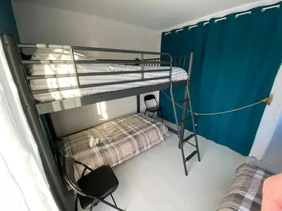 a bunk bed in a room with two beds at L'écume d'or T3 in Port-la-Nouvelle
