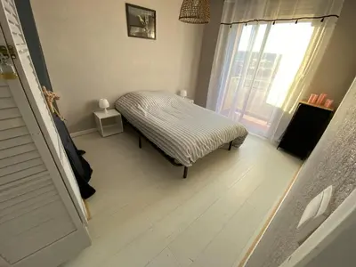 a small room with a bed and a window at L'écume d'or T3 in Port-la-Nouvelle