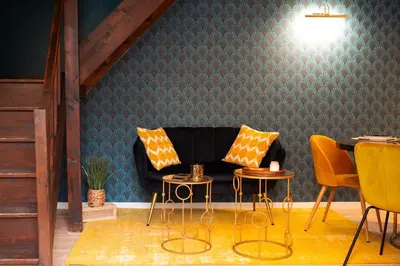 a living room with a couch and two tables and chairs at l'écrin du désir in Capestang