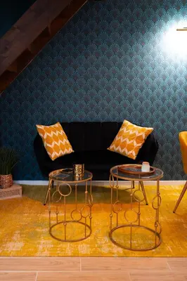 a living room with a black couch and two tables at l'écrin du désir in Capestang