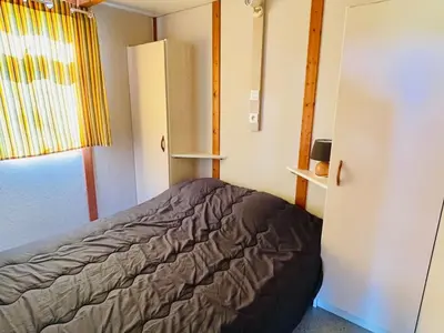 a small bedroom with a bed and a refrigerator at Chalet avec Terrasse à Camon - API-1-52-902 in Camon