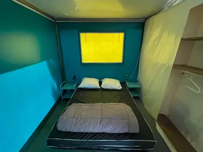 a small room with two beds in it with a window at Bungalow 3 Pièces avec Terrasse - API-1-52-888 in Camon