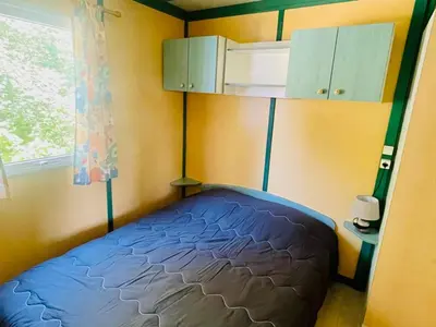 a small bedroom with a bed and a window at Chalet cosy avec terrasse pour 4 personnes - API-1-52-919 in Camon