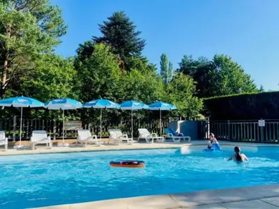 two people in a swimming pool with umbrellas at Chalet 18m², Terrasse sur Pilotis, 4 Personnes - API-1-52-927 in Camon