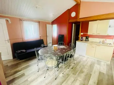 a kitchen with a table and chairs in a room at Chalet 8 pers avec Terrasse - API-1-52-1027 in Camon