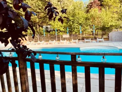 a swimming pool in a park with a wooden fence at Mobil-home 3 pièces avec terrasse à Camon - API-1-52-1043 in Camon