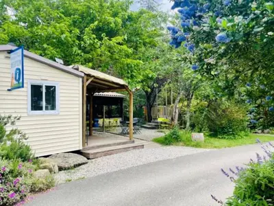 a small white building with a gazebo at Mobil-home 3 pièces avec terrasse à Camon - API-1-52-1043 in Camon