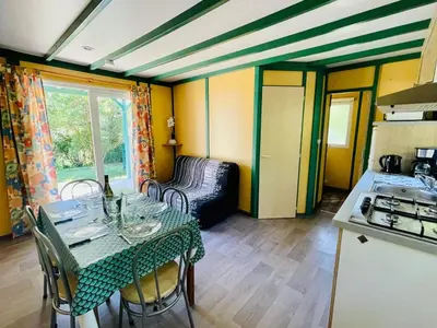 a dining room with a table and a kitchen at Chalet Confort 6 Pers - Terrasse - API-1-52-1032 in Camon