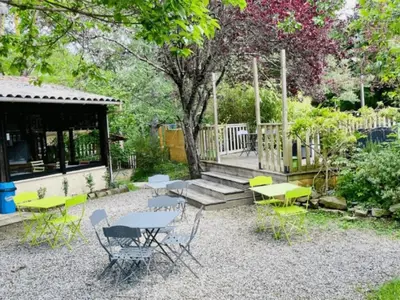 a group of tables and chairs in a garden at Chalet de 26m² avec Terrasse pour 4 Personnes - API-1-52-1070 in Camon