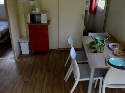a kitchen with a table and chairs in a room at Chalet confortable 4 pers avec terrasse - API-1-52-1139 in Camon