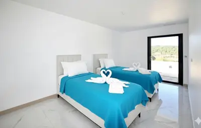 two beds in a room with blue sheets and white towels at Villa Avec Piscine Privée in Portel-des-Corbières