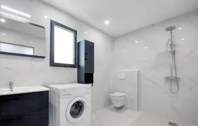 a white bathroom with a washing machine and a sink at Villa Avec Piscine Privée in Portel-des-Corbières