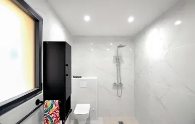 a white bathroom with a shower and a toilet at Villa Avec Piscine Privée in Portel-des-Corbières