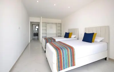 two beds in a room with white walls at Villa Avec Piscine Privée in Portel-des-Corbières
