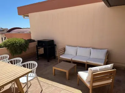 a patio with a couch and a table and chairs at Elégant T3, vue sur le port - Grande terrasse in Gruissan