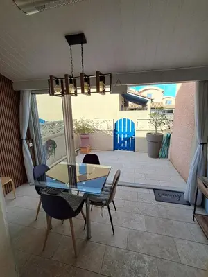 a dining room with a glass table and chairs at location maison gruissan in Gruissan