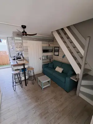 a living room with a green couch and a table at location maison gruissan in Gruissan