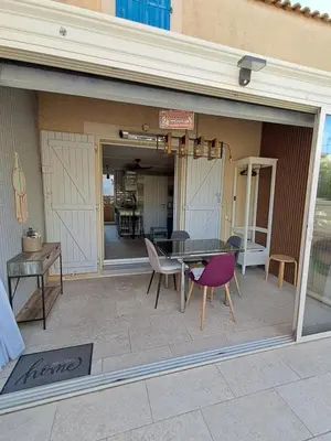 a patio with a table and chairs in front of a building at location maison gruissan in Gruissan