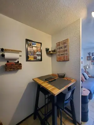 a small table in a room with a sign on the wall at Studio Horizon - Parking Commerces Plage in Port-la-Nouvelle