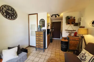 a living room with a dresser and a kitchen at Studio Horizon - Parking Commerces Plage in Port-la-Nouvelle