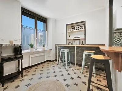 a kitchen with a counter and stools in a room at Suite Privative Design au Cœur de Trèbes in Trèbes