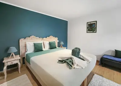 a bedroom with a large bed with blue walls at Suite Privative Design au Cœur de Trèbes in Trèbes