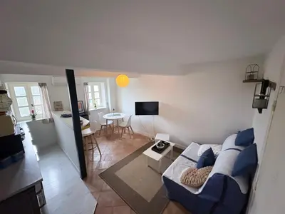 a living room with a couch and a table at Studio confortable en plein centre proche gare & commerces in Villefranche-de-Lauragais