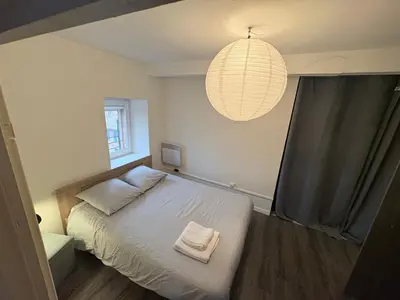 a bedroom with a bed and a pendant light at Studio confortable en plein centre proche gare & commerces in Villefranche-de-Lauragais