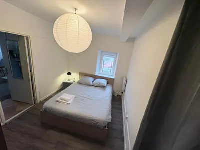 a small bedroom with a bed and a pendant light at Studio confortable en plein centre proche gare & commerces in Villefranche-de-Lauragais