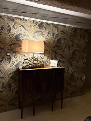 a room with a table with a lamp on a wall at La petite Chaumière in Bouilhonnac