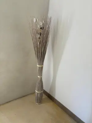 a vase with sticks in it sitting on the floor at La petite Chaumière in Bouilhonnac