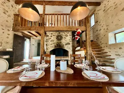 a dining room with a table and a fireplace at Mas Sarava - Retraite détente - Pilates et Massage in Espira-de-lʼAgly