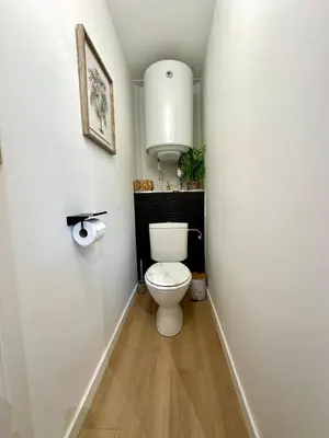a bathroom with a white toilet in a hallway at Charmant deux pièces en plein centre-ville de NARBONNE in Narbonne