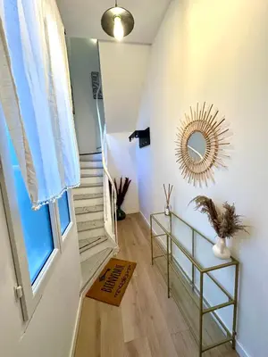 a hallway with a staircase with a mirror on the wall at Charmant deux pièces en plein centre-ville de NARBONNE in Narbonne