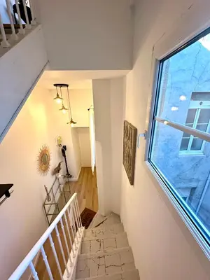 a staircase in a house with a large window at Charmant deux pièces en plein centre-ville de NARBONNE in Narbonne