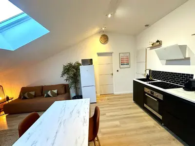 a kitchen and living room with a couch and a table at Charmant deux pièces en plein centre-ville de NARBONNE in Narbonne