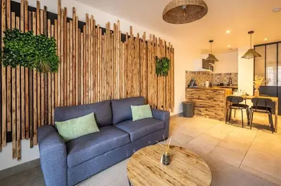 a living room with a blue couch and a table at Chez le Golfeur - Cœur & Vignes in Carcassonne