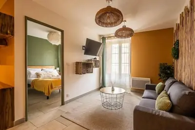 a living room with a couch and a bedroom at Chez le Golfeur - Cœur & Vignes in Carcassonne