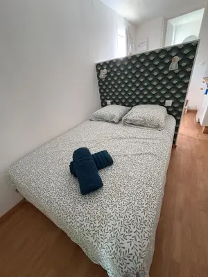 a bed with a blue towel on top of it at Charles de Gaulle lll - Independent Garden in Castres