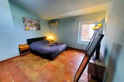 a bedroom with a bed in the corner of a room at La Tomette 3 chambres avec joli patio in Sigean