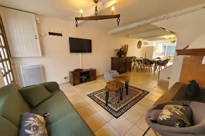 a living room with a couch and a tv at La Tomette 3 chambres avec joli patio in Sigean