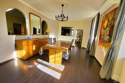 a dining room with a wooden table and a chandelier at Gîte Le Mississipi in Narbonne
