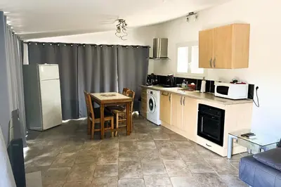 a small kitchen with a table and a microwave at Gîte Piscine in Narbonne