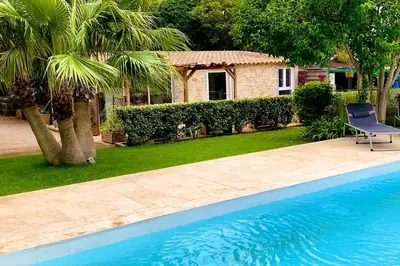 a chair sitting next to a swimming pool at Gîte Piscine in Narbonne