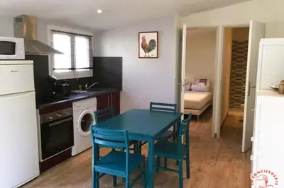 a kitchen with a blue table and chairs in a room at Gîte Jardin in Narbonne