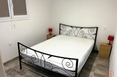a bedroom with a black and white bed in a room at Gîte Jardin in Narbonne