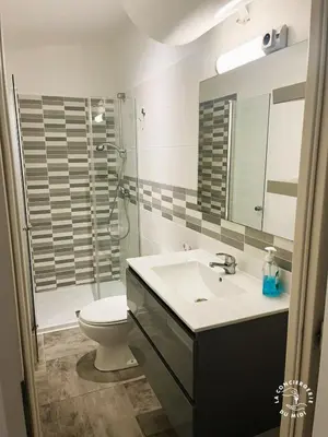 a bathroom with a sink and a toilet and a mirror at Gîte Jardin in Narbonne