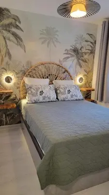a bedroom with a large bed in a room at Le Tropical in Port-la-Nouvelle