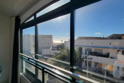 a window in a room with a view of a building at Le Tropical in Port-la-Nouvelle