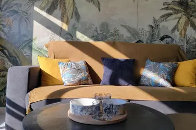 a living room with a couch and a table at Le Tropical in Port-la-Nouvelle